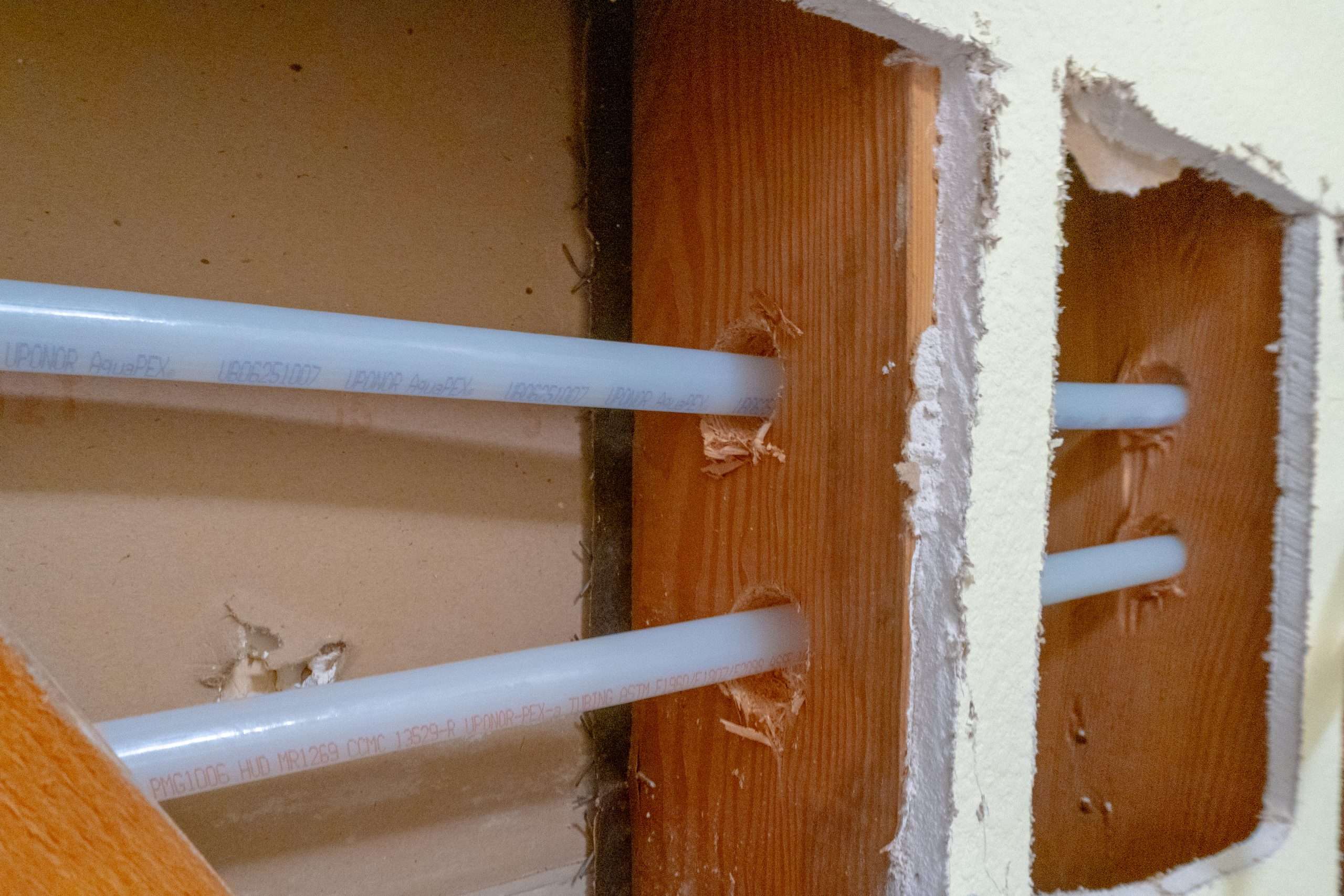 USA-made PEX plumbing pipes installed inside a wall during a whole house repipe.