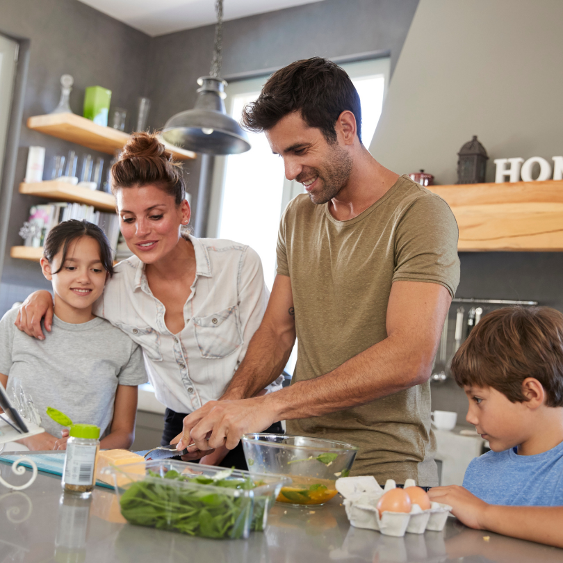 Happy family cooking together in kitchen with peace of mind after home repipe and no plumbing worries