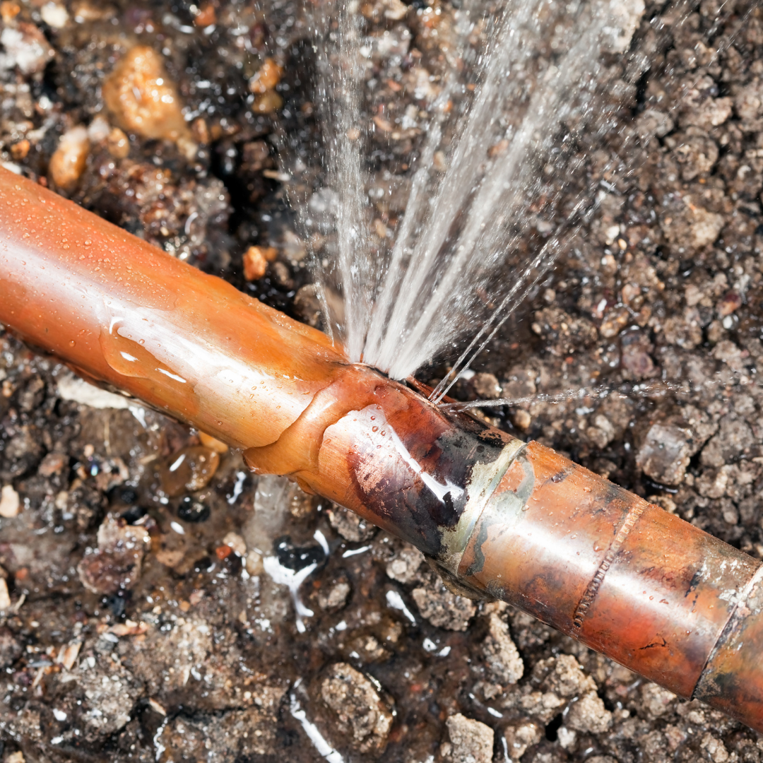 tubería de cobre rota con fuga de agua en el suelo mostrando una fuga en la losa que requiere cambio de plomería